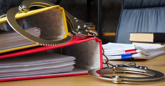 criminal records and handcuffs on table