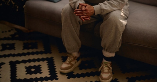 person sitting down with ankle monitor