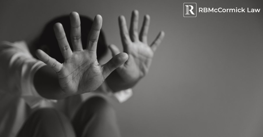 person with their hands raised in a frightened stance